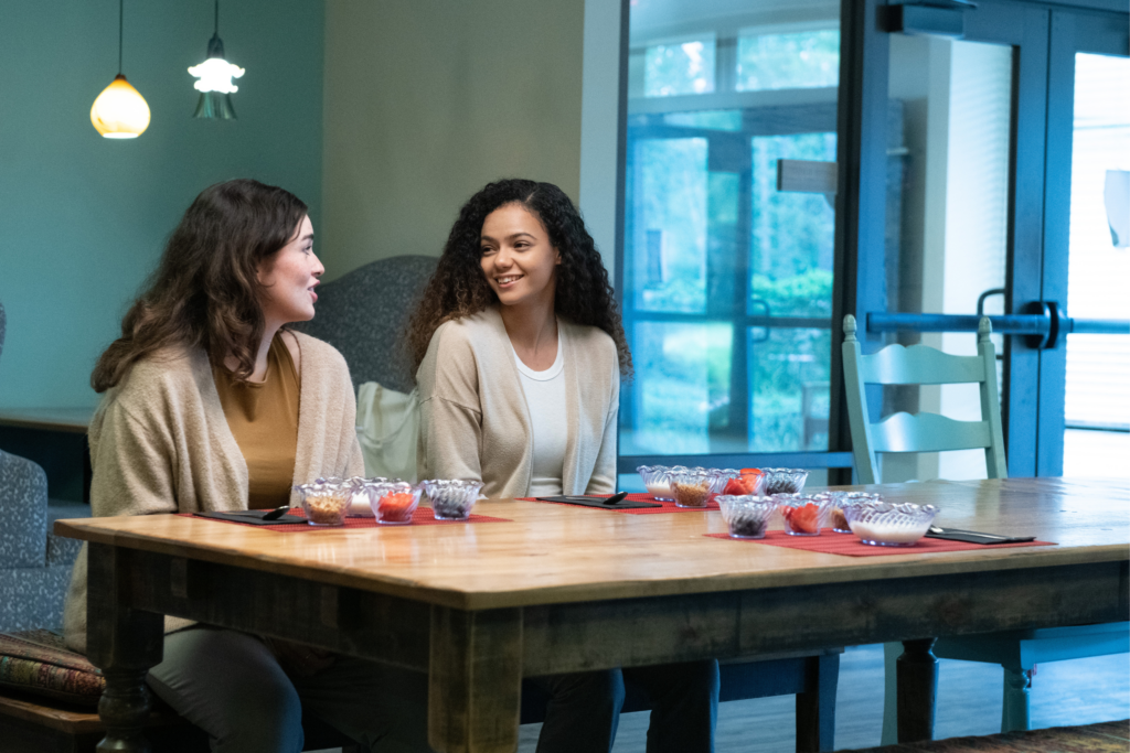 Women at table smiling.